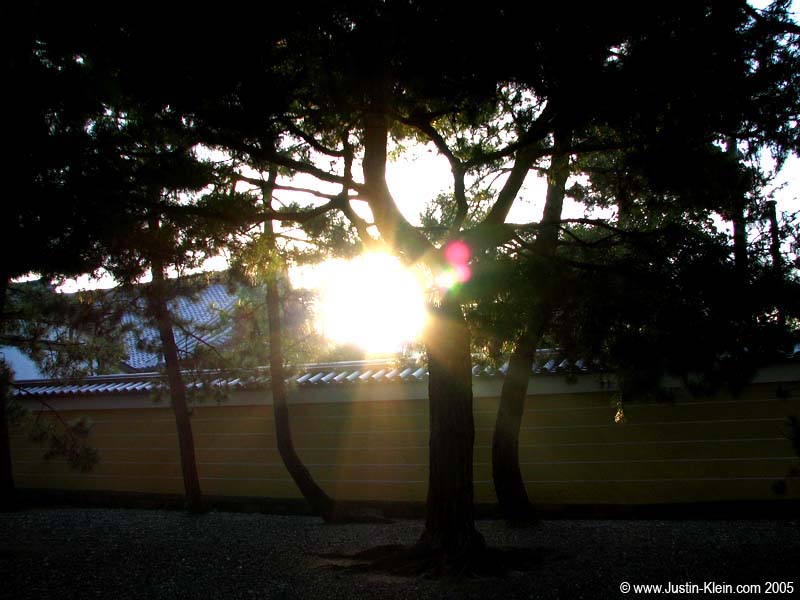 The early morning sun peeks over a temple wall.