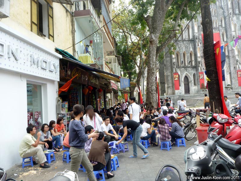This isn&#8217;t actually Bia Hoi Junction but the concept is the same: small stools by the side of the road where people sit, snack, talk, and drink.